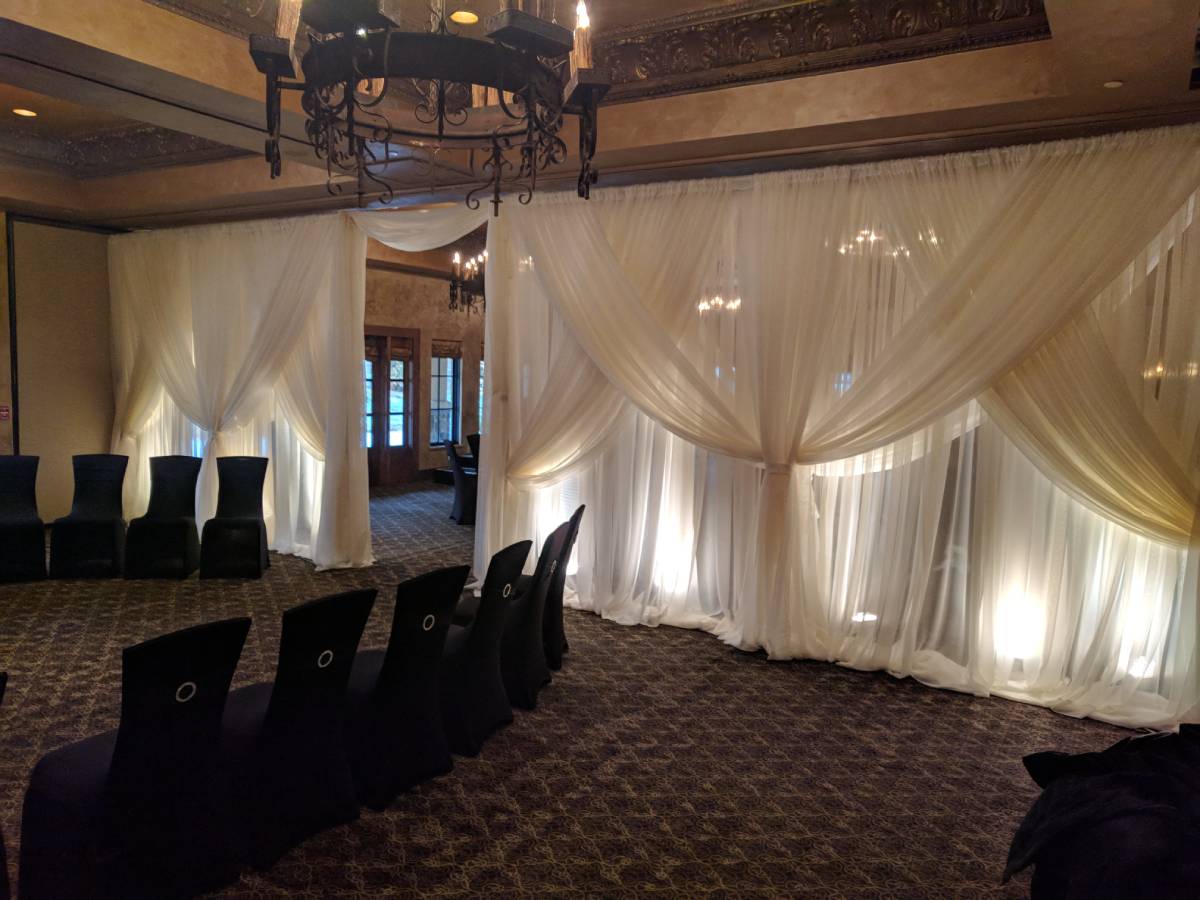 Sheer Ivory Backdrop With Sheer Ivory Front Layer Crisscrossed Tied With Uplights